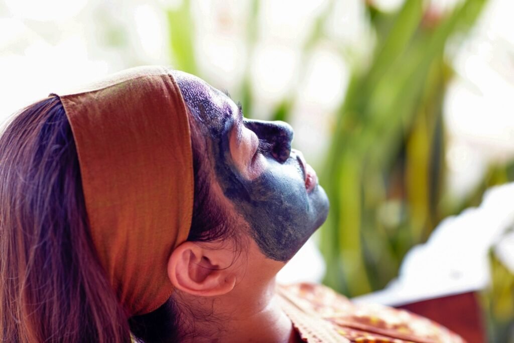 Man receiving a facial mask treatment, lying down with eyes closed