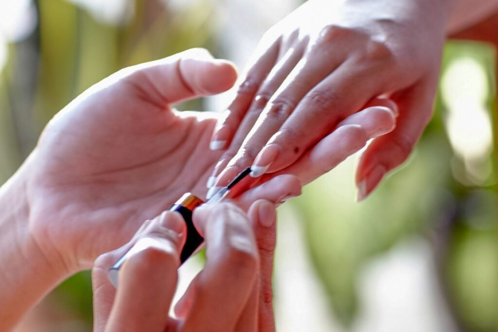 Close-up of a manicure in progress with a person applying nail polish.