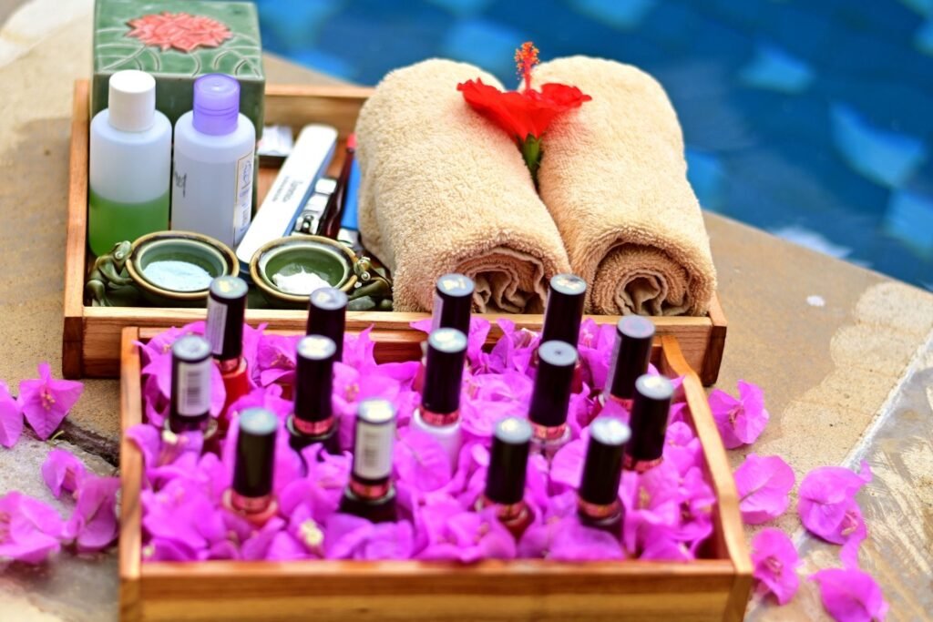 Tray with nail polish bottles, spa towels, and flower petals arranged neatly