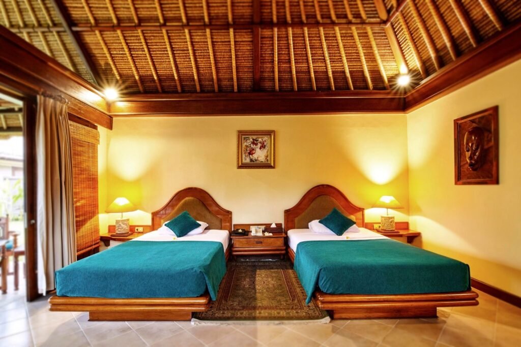 "Cozy twin-bed room with high wooden ceiling and warm ambient lighting."