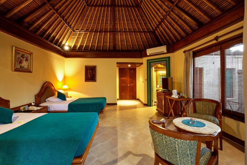 "Spacious garden-view room with rattan furniture and tropical decor."