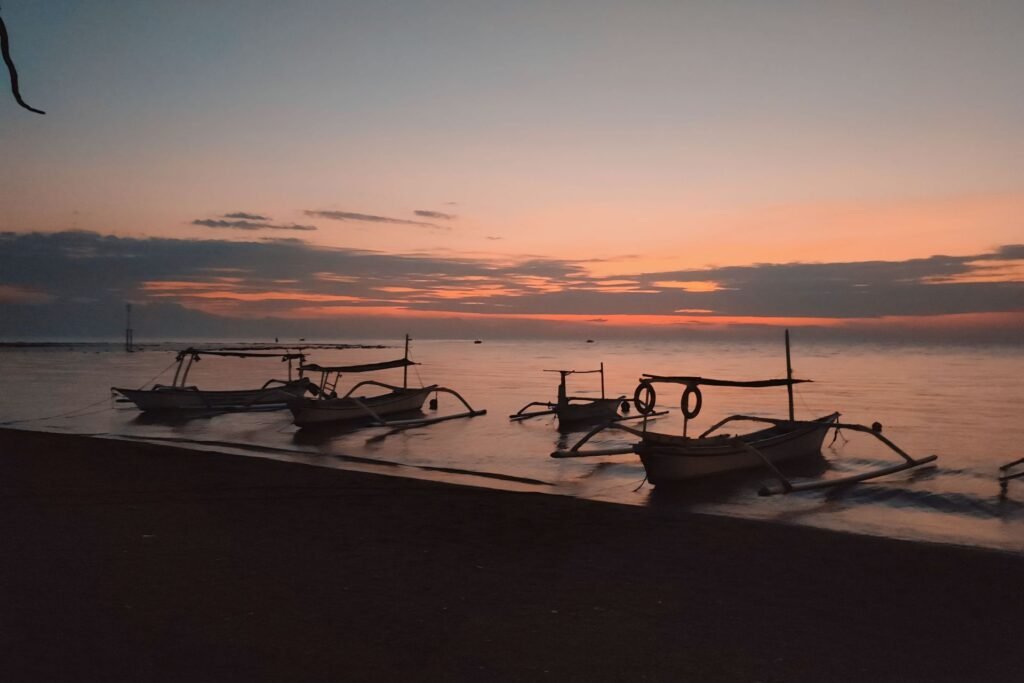 Sunset at Lovina Beach with traditional fishing boats on calm waters
